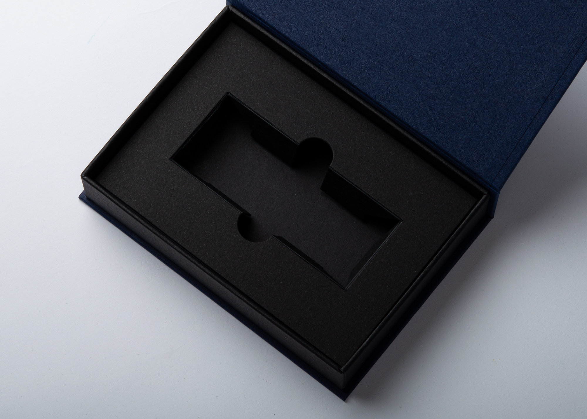 Geöffnete Magnetbox mit schwarzem Kartoninlay und Produktausstanzung