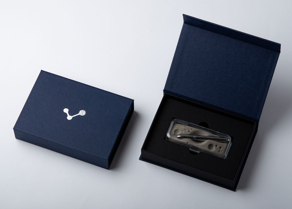 Geschlossene und geöffnete blaue Magnetbox mit Produkt im schwarzen Inlay
