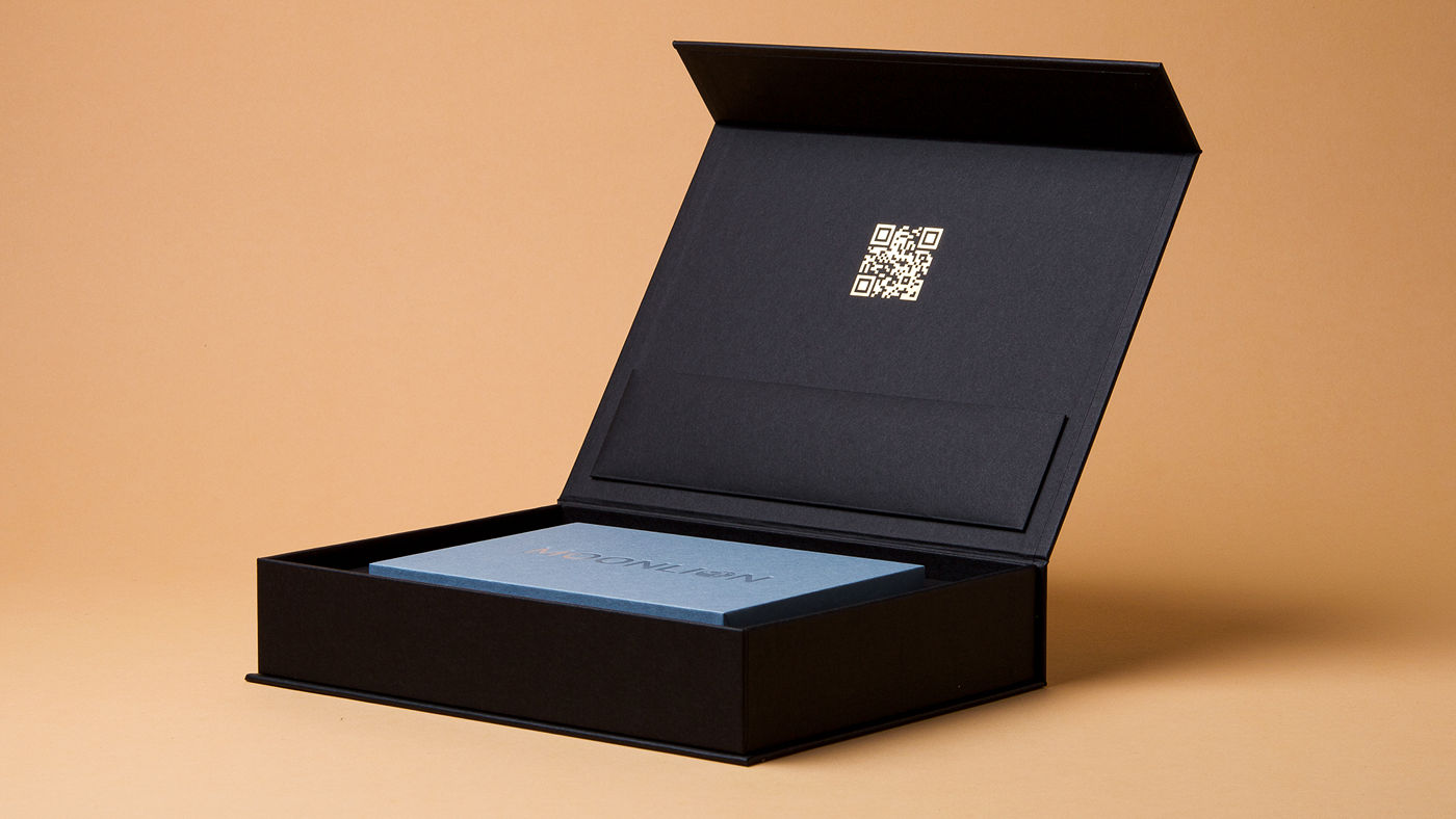Geöffnete schwarze Magnetbox mit QR-Code im Deckel und blauem Einleger