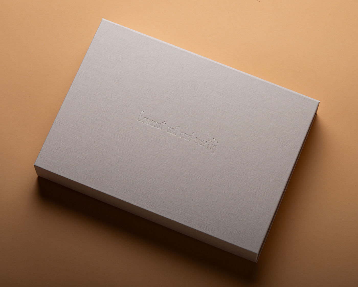 Produktverpackung aus FINELINEN in Perlbeige mit transparenter Heißfolienprägung und Ablagefach